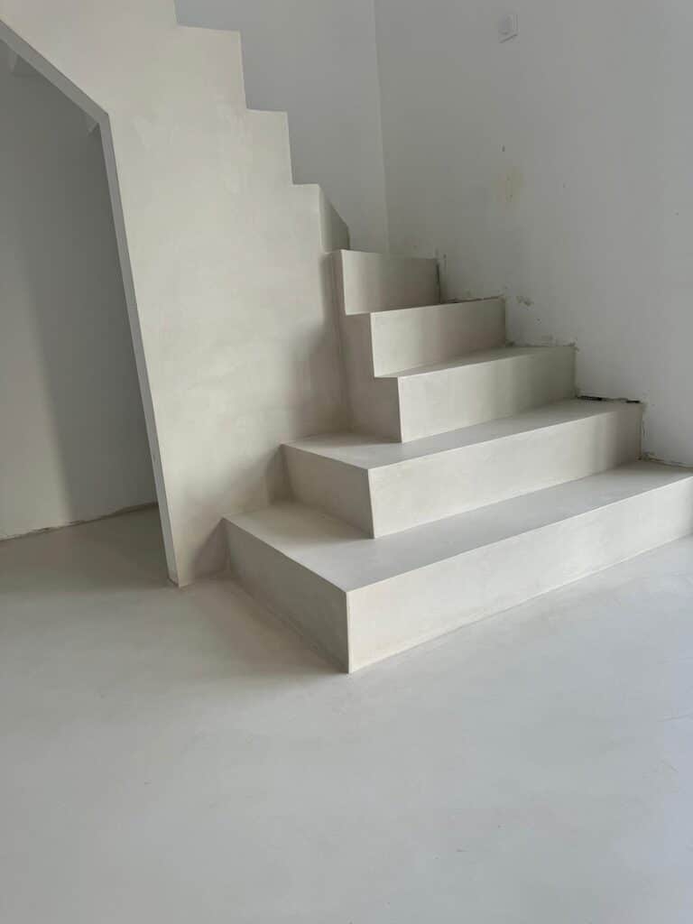 Escalier béton blanc, marches larges et géométriques, design épuré dans un intérieur moderne et lumineux.