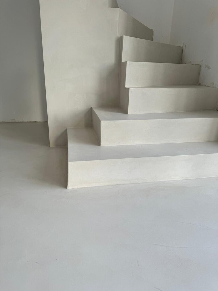 Escalier minimaliste en béton ciré gris clair, lignes épurées, finitions modernes et intemporelles.