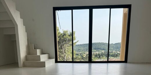 Minimaliste : escalier moderne, sol blanc, vue nature majestueuse.