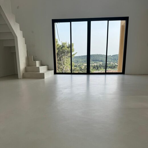 Minimaliste : escalier moderne, sol blanc, vue nature majestueuse.